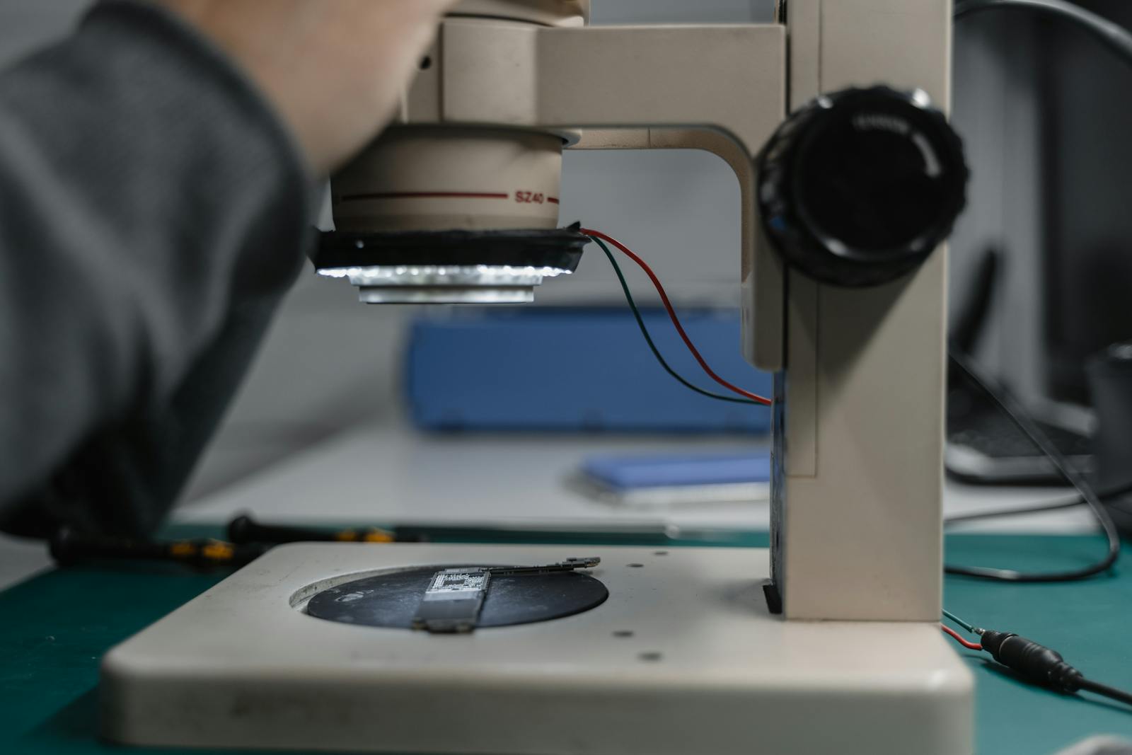Detailed view of a microscope used in electronic device examination in a lab setting.
